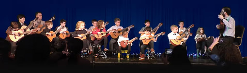 15 Students and 2 Teachers performing guitar together at The Rotunda in Philadelphia